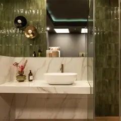 Elegancka łazienka z zielonymi płytkami, umywalką i lustrem. Inspiracja dla miłośników stylu, jak domino płytki Kraków.