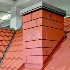 Nowoczesny komin z cegły z grafiką domu i chmur. Ocieplenie komina zapewnia efektywne odprowadzanie spalin i chroni przed utratą ciepła.