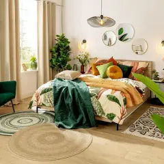 Zielony, jaki kolor uspokaja, dominuje w tej sypialni. Bujna roślinność i zielony fotel tworzą oazę spokoju.