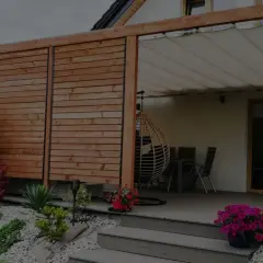 Nowoczesny taras z deski kompozytowej, z pergolą i huśtawką. Zastanawiasz się, ile kosztuje zrobienie tarasu z deski kompozytowej?