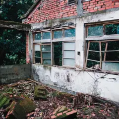 Ruiny z rozbitymi oknami i gruzem na podłodze. Wskazówki, jak przygotować okna z demontażu do odbioru, mogą być przydatne nawet w takim miejscu.