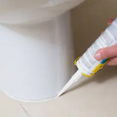 Aplikacja silikonu sanitarnego wokół toalety. Czekamy, aż silikon sanitarny wyschnie, aby zapewnić szczelność.