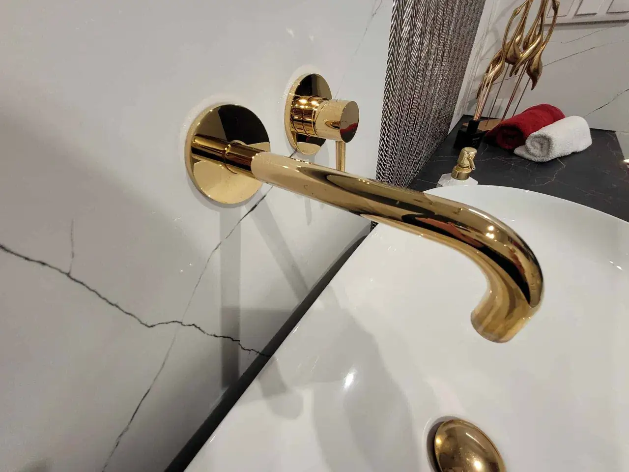 Elegancka, złota armatura łazienkowa z baterią ścienną i umywalką.