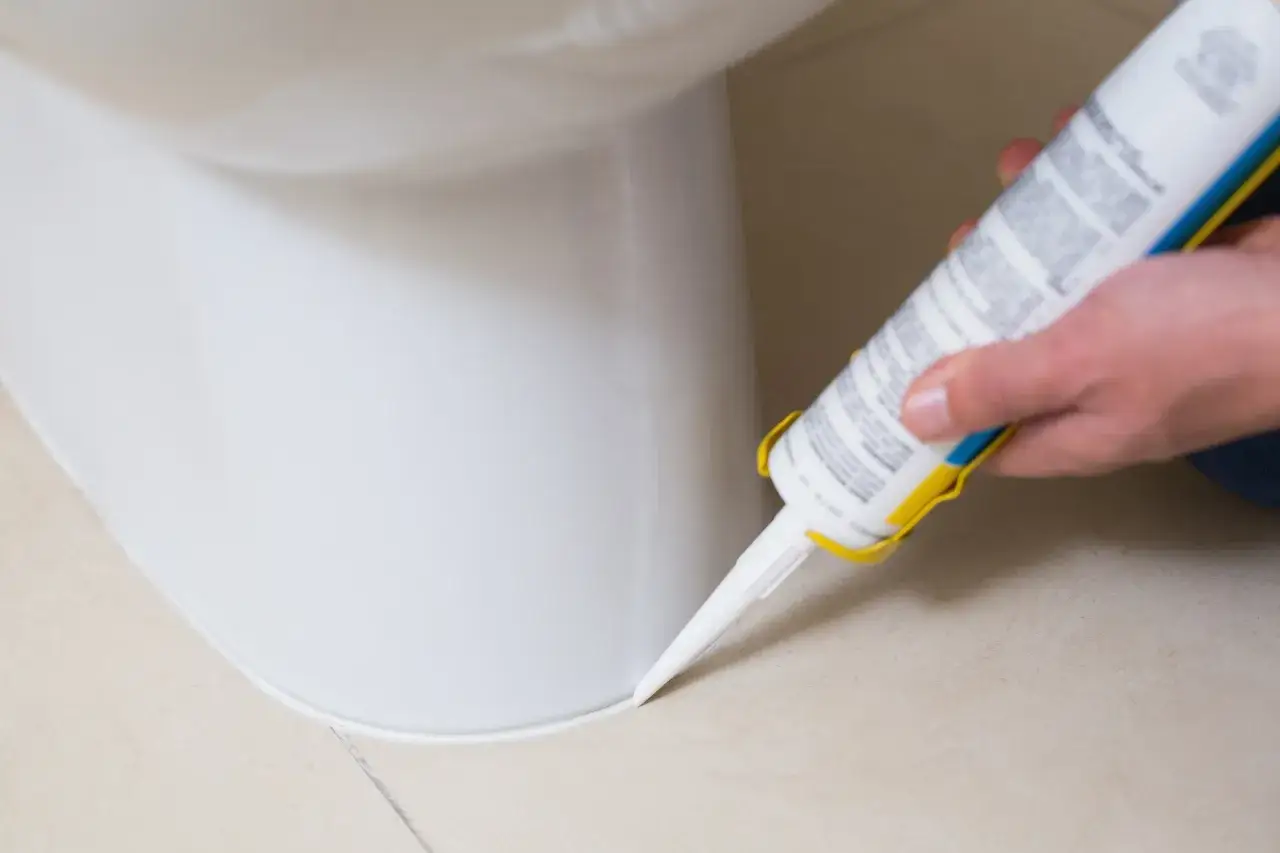 Aplikacja silikonu sanitarnego wokół toalety. Czekamy, aż silikon sanitarny wyschnie, aby zapewnić szczelność.