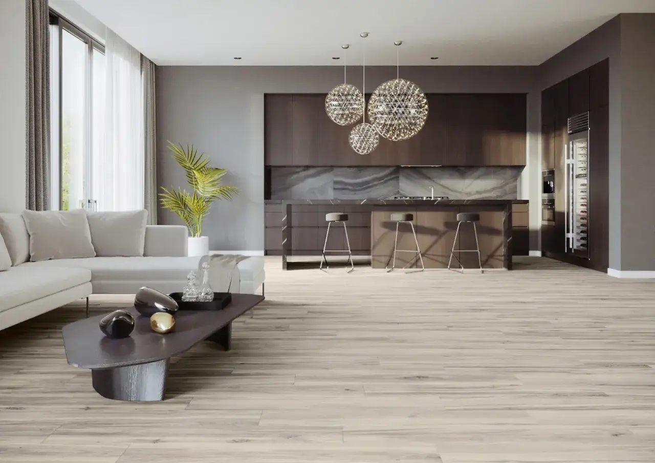 Nowoczesny salon z aneksem kuchennym, gdzie podłogę pokrywają jasne płytki imitujące drewno. Wygodna sofa i designerski stolik kawowy tworzą przytulną strefę wypoczynkową.