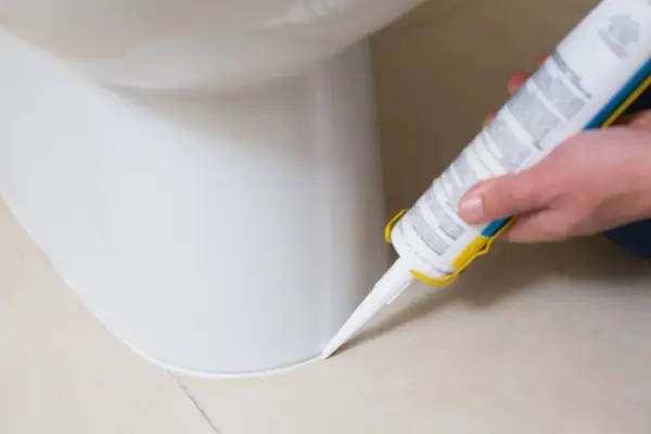 Aplikacja silikonu sanitarnego wokół toalety. Czekamy, aż silikon sanitarny wyschnie, aby zapewnić szczelność.